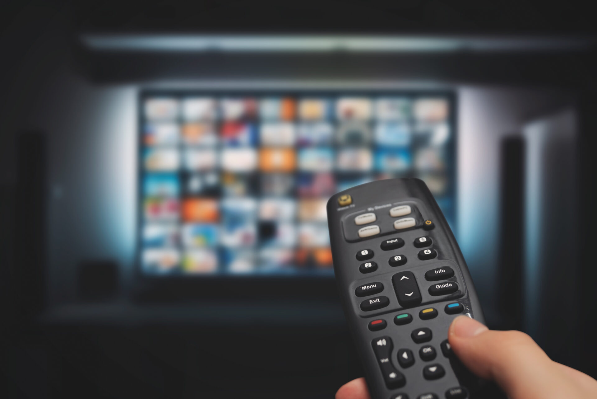 VOD service on television. Man watching TV, streaming service, video on demand, remote control in hand.