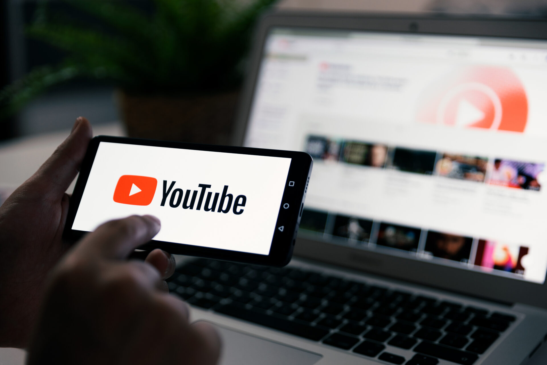 Wroclaw, Poland - OCT 23, 2019: Man holding smart phone with YouTube logo on screen. YouTube is most popular video service developed by Google.