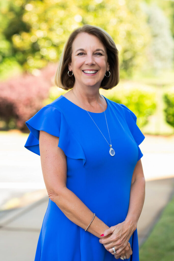 Headshot of a team member at Layson, Treadwell & Spires, CPAs. She is standing outside on a sidewalk with the street and a tree-heavy setting as the backdrop.